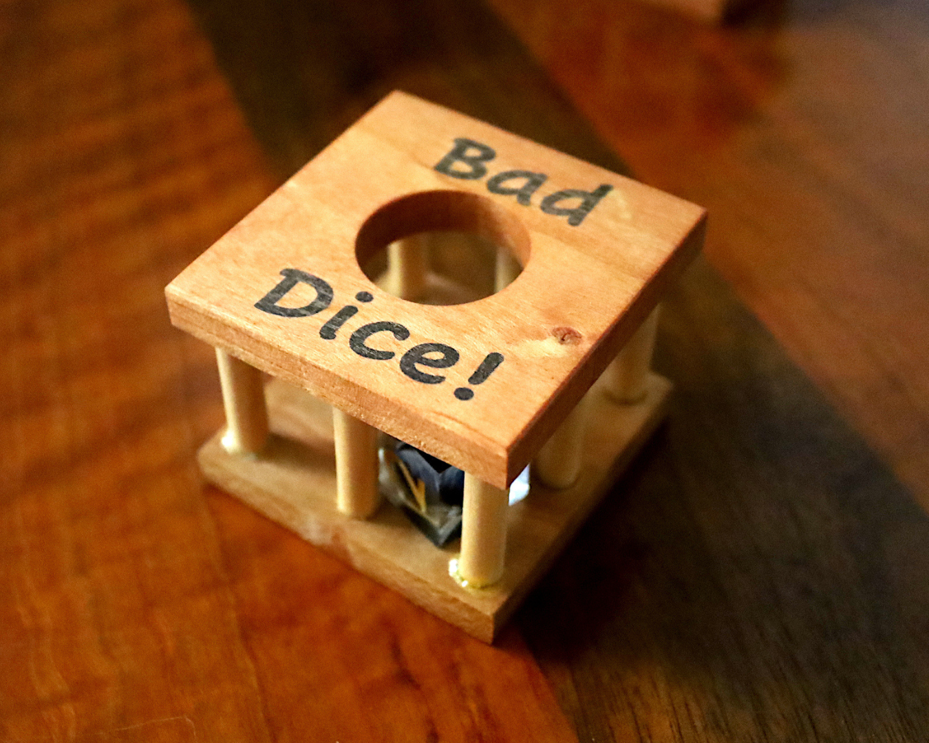 Square wooden dice jail that says "Bad Dice!"