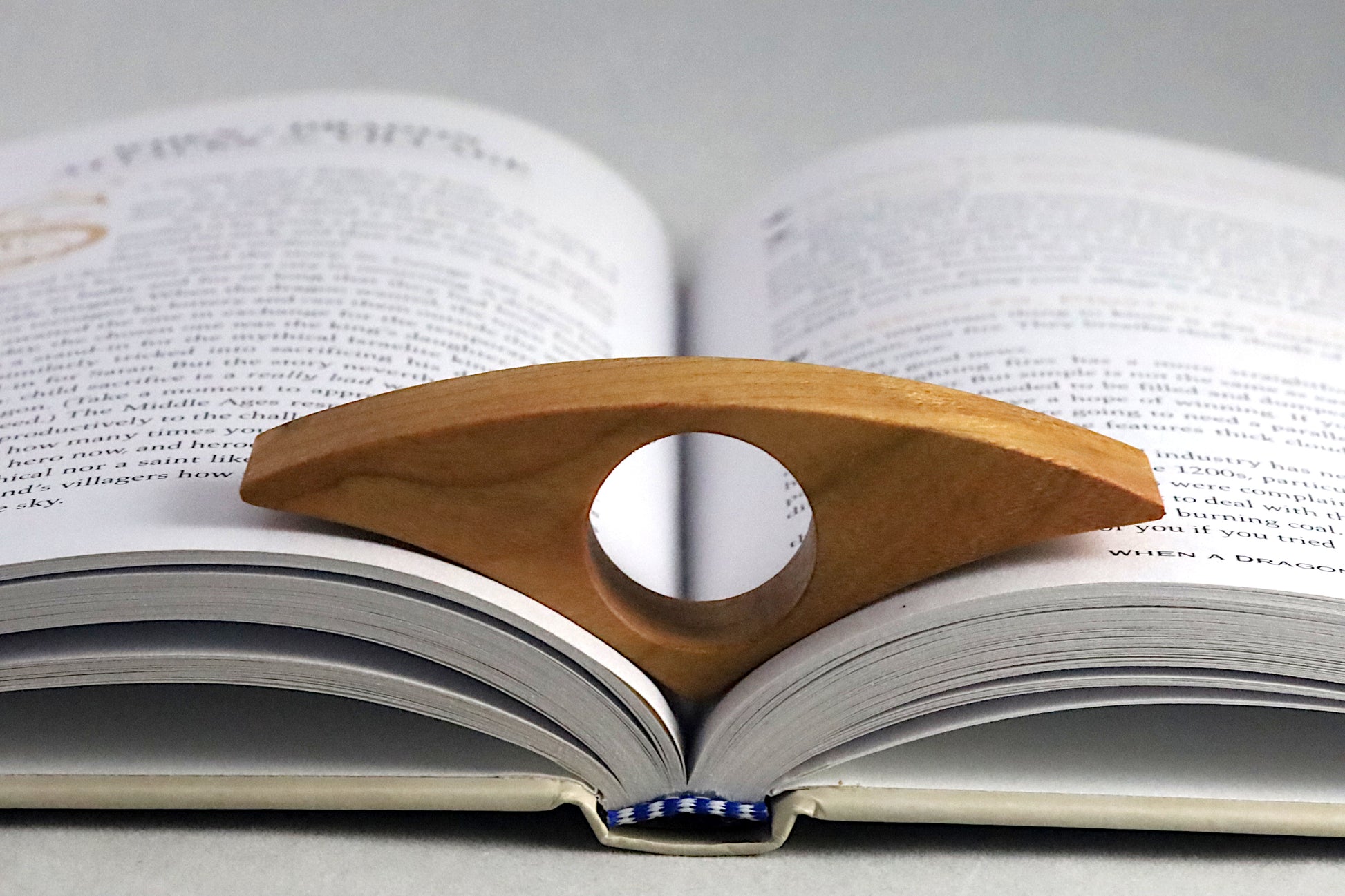 Cherry book page holder on an open book
