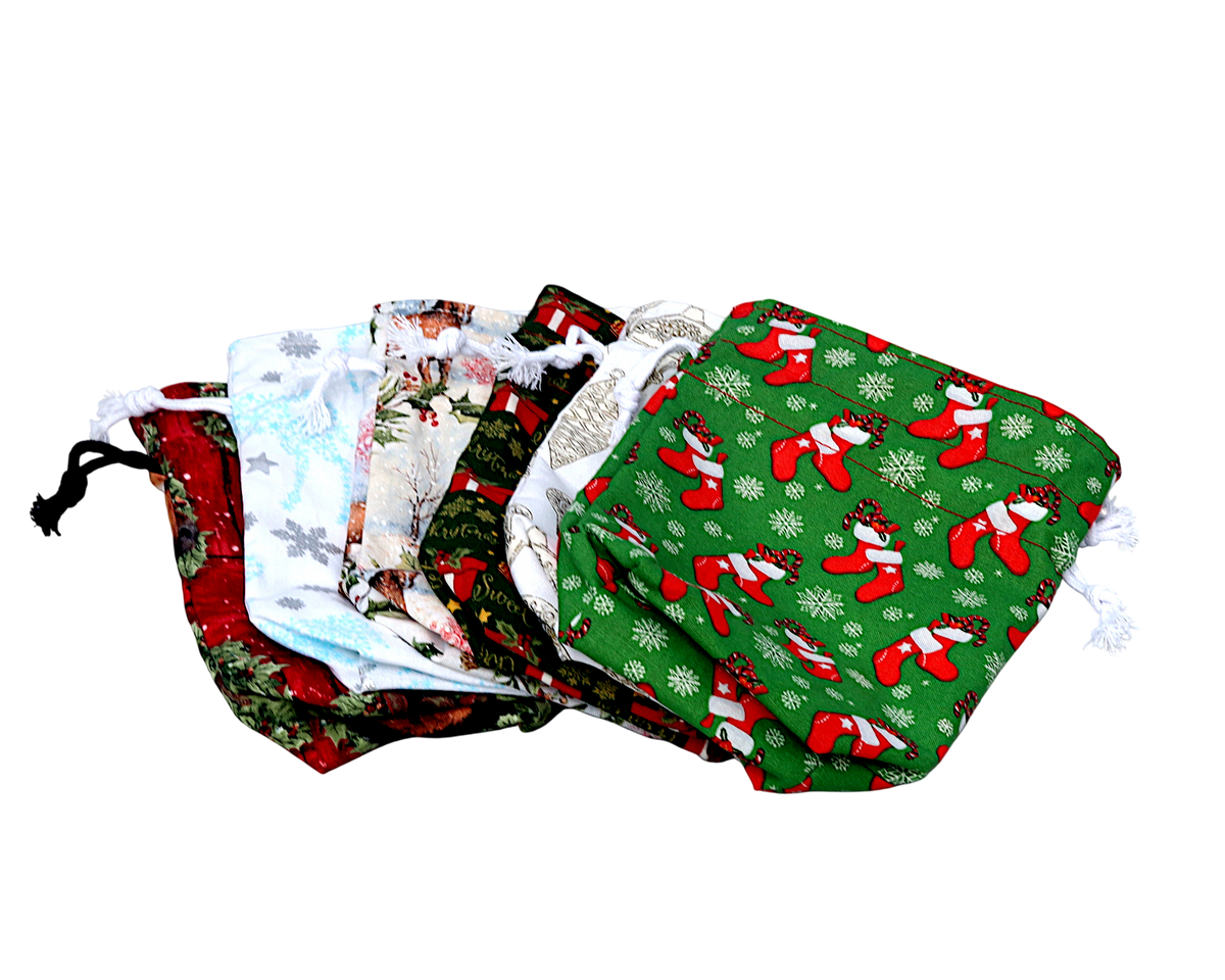 A set of six small fabric drawstring dice bags with various Christmas-themed patterns, including a prominent green bag with red stockings and white snowflakes, displayed against a plain white background.