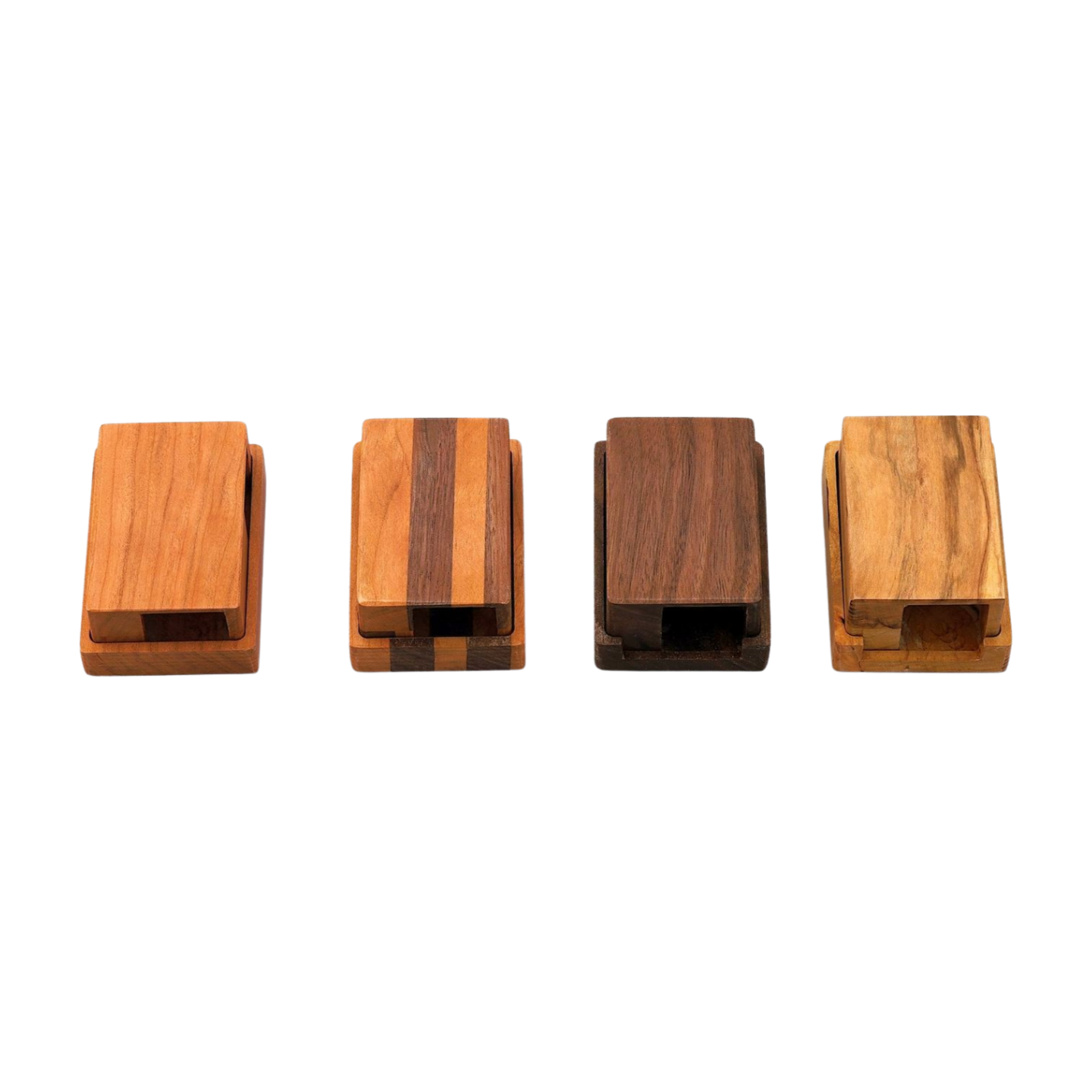 Four wooden dice towers stored in dice trays with different wood types on a white background
